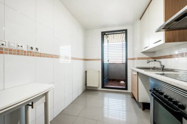 Kiralık bir dairede kurutma terasına erişimi olan bir mutfak.