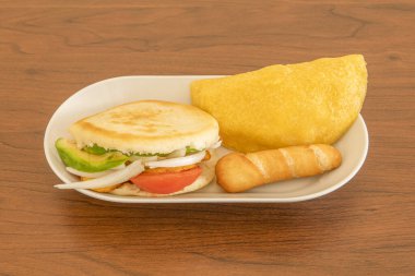 Venezuela aperatifli küçük tepsi, domatesli arepa, muz soğanı ve avokado, taze peynir ve mısır unu empanadasıyla doldurulmuş tekke.
