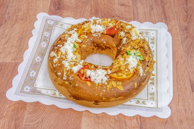 Geleneksel Roscon de Reyes içi şekerli meyvelerle dolu ahşap masa