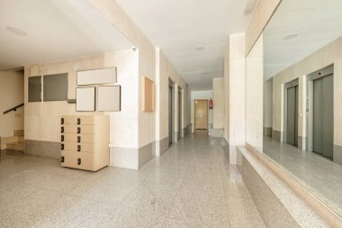 Granit zeminli binaya giriş kapısı, hızlı teslimat çekmecesi, merdiven ve metal asansörler.