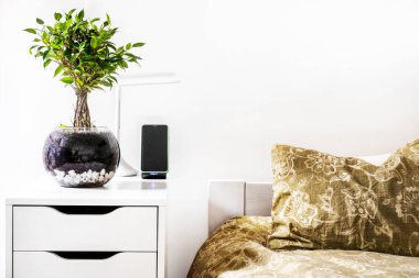 Küçük fitilli yatak başlığı, yastıklar ve akıllı telefon tutacağı.