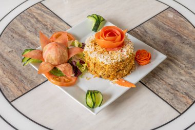 Bu tarifte karides güvecini iyi bir tabaka basmati pilavının altında bulabilirsiniz. Son olarak, safranla doldurulmuş su pirinci güzel sarı bir renge boyamak ve aromayla doldurmak için dökülür..