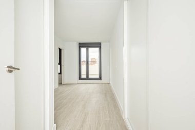 Boş odaya giriş kapısı, yeni boyanmış duvarlar, küçük sürgülü kapılar.