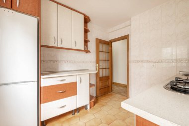 Kitchen with wooden cabinets combined with white cabinets and appliances