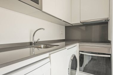 Kitchen with white cabinets and gray granite countertops and stainless steel appliances