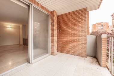Terrace of urban house with white ceramic floors and entrance to a living room