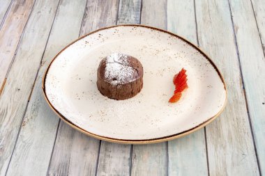creamy chocolate coulant that melts inside with syrup, strawberries and icing sugar