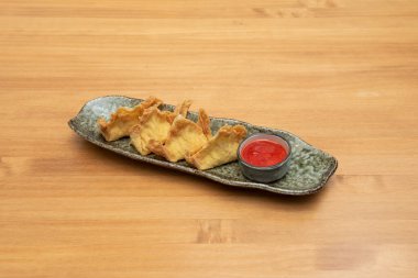 Crab Rangoon is a deep-fried dumpling served in Chinese-American cuisine and Thai restaurants, filled with a combination of cream cheese, lightly crumbled crab meat, onion, and garlic.