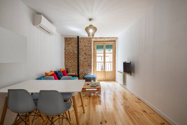Dining table in a vacation rental apartment with exposed brick wall wood stove metal pipe
