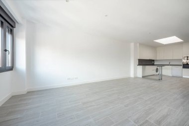 Bir ucunda mutfak, diğer ucunda pencere olan büyük boş bir oda..