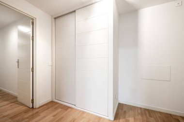 Meşe parke döşemeli beyaz sürgülü dolap.