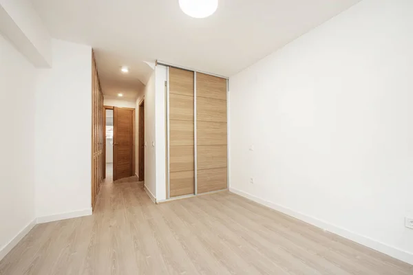 同じ材料のライトオーク材と床のスライドドアと通常のドア付きのワードローブを備えたベッドルーム — ストック写真