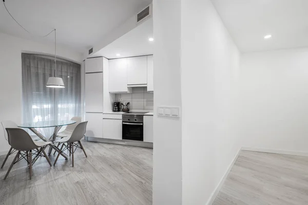 有圆形玻璃餐桌和灰色地板的走廊和白色厨房 — 图库照片