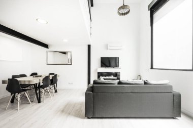 Kısa süreli kiralık bir çatı katında televizyon ve yemek odası olan oturma odası.