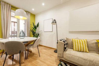 Yuvarlak masalı yemek salonu ve kiralık bir dairede yastıklı kanepe.