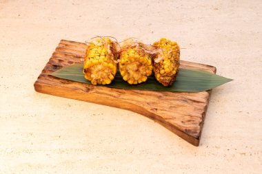 Közlerin üzerinde kavrulmuş ya da kızartılmış mısır koçanı.