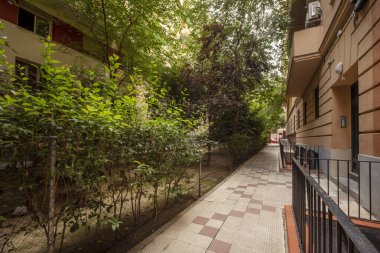 Bahçeleri ve ağaçları olan kentsel konutlara giriş salonu.