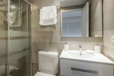 Beyaz reçine lavabolu geleneksel tuvalet çerçevesiz kare ayna ve ekranla duş.