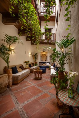 Ferahlatıcı verandası ve birçok bitkisi olan Müslüman bir binanın içinde.