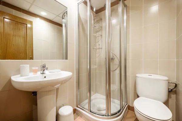 Bathroom with porcelain pedestal sink and recessed rectangular mirror and shower with aluminum screen