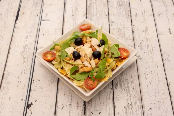Pasta salad is a quick and easy recipe. This one with farfalle, the one enriched with chicken breast, zucchini, cheese, black olives, arugula and cherry tomatoes.