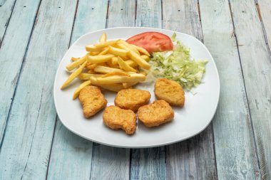 tavuk eti, ağırlıklı olarak kıyma, bazen tavuk derisi, bazı durumlarda da iç organlar, ezilmiş kemikler, yağ, damarlar, sinirler, kıkırdak ve hamurla kaplı yaklaşık 30 katkı maddesi eklenir.