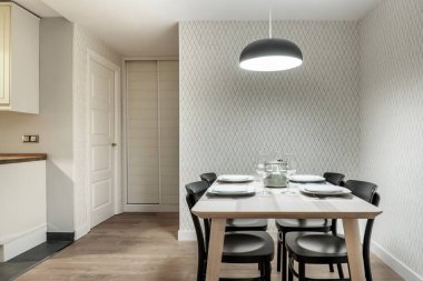 Modern bir mutfak ofisinde siyah sandalyeli yemek masası.