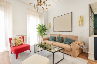 Cam masalı oturma odası, deve kumaşlı kanepe, kırmızı koltuk ve dizayn lambaları.