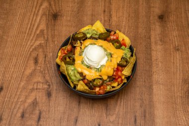 Guacamole ve peynirli nachos, misafirlerinize hızlı ve lezzetli bir yemek seçeneği sunabileceğiniz kolay bir yemektir..