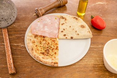 Bolonya soslu çıtır pizza, peynirsiz, yağlı, kekik ve biberli ahşap masa.
