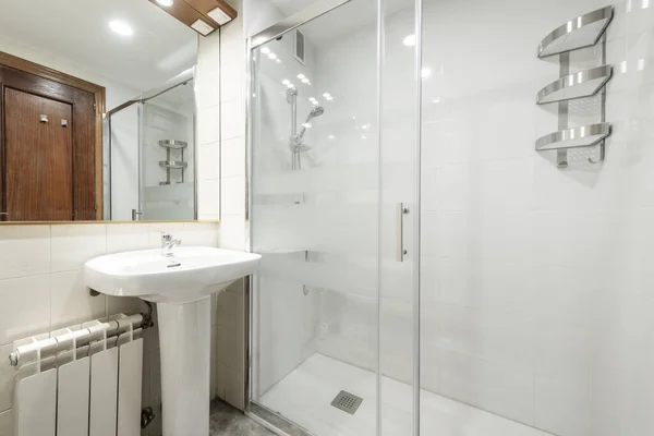 シンクと大きなフレームレスガラスミラー ガラス棚 緑と白のタイルと白のアルミラジエーターと白い浴槽にガラスパーティションを持つトイレ — ストック写真