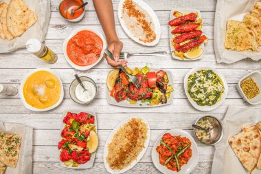 Hint yemekleri, kızarmış tavuk tikka masala, sarımsak naan, yoğurt kreması, korma, tandır tavuğu, domates salatası, palak paneer, biber, basmati pilavı ve çatalla tavuk bıçaklama