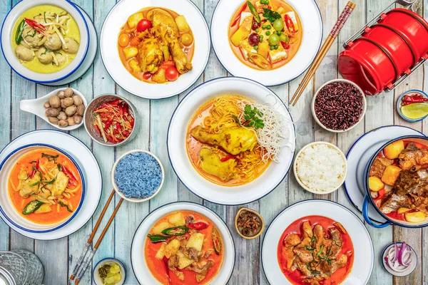 Baharatlı baharatlı Tayland yemekleri, haşlanmış tavuk, renkli pilav, domuz güveci, baharatlar, yemek çubukları, limon ve kırmızı biber.