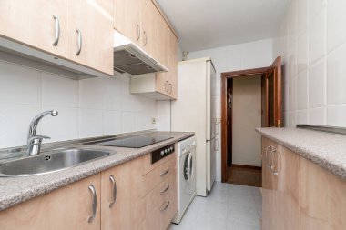 Mobilyalı mutfak, benzer pembe granit tezgah, beyaz eşyalar ve kiralık bir dairede siyah seramik hob.