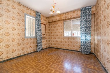 Duvarları eski püskü çiçeklerle kaplı ve mümkünse daha şık perdeli alüminyum pencereli bir oda.