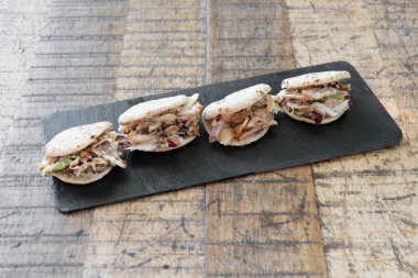 Çeşitli mini pide tepsileri. Havuç ve yoğurt soslu biftek kebabı. Kebap soslu tavuk ve kızarmış soğan..