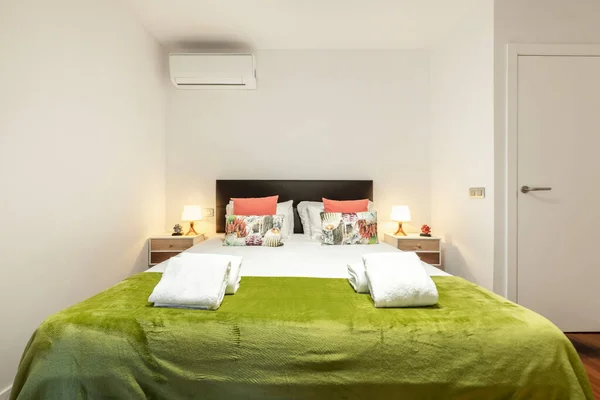 有特大床的卧室 配有配套的垫子和双人椅 黑色内衬床头柜和绿色毛毯 — 图库照片