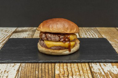 Duble çizburger, bir tutam tuz ve biber, hardal ve iki parça erimiş Amerikan peyniri ile baharatlı iki parça saf et içerir.