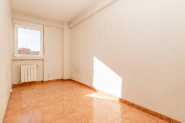 Altında alüminyum pencere ve alüminyum radyatör olan boş oda