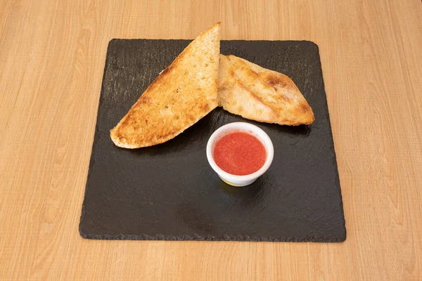 Bir dilim kızarmış ekmek. Ülkeye bağlı olarak, farklı şekillerde çağrılabilir ve bunlar farklı olabilir. Tostun kahverengimsi rengi Maillard reaksiyonundan kaynaklanıyor..