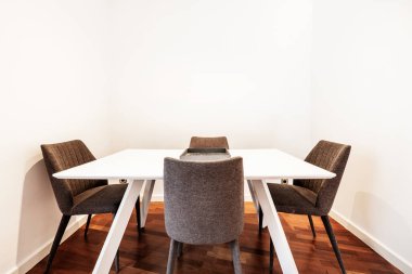 Kumaş kaplama sandalyeli beyaz yemek masası