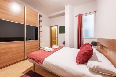 Kral yatak odası, ahşap ve cam sürgülü kapı gardırobu, kırmızı kumaş detayları ve ahşap döşeme.