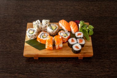Suşi tepsisi ve uramaki California Roll, somon nigiri, ton balığı maki, avokado ve surimi uramaki, nori seaweed, masago roe, haşhaş ve susam tohumları.