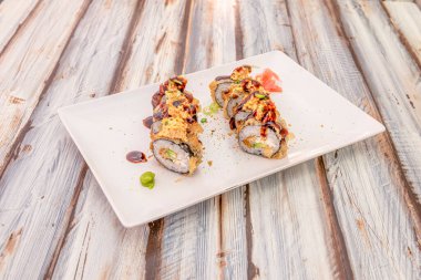 Yağlı maki rulo suşi ile Norveç yosunu, krem peynir, soya sosu, çıtır soğan, avokado ve taze soğan.