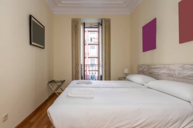İki yatak odası, beyaz yatak odası, ahşap yatak başlığı, beyaz marangoz, ahşap panjurlu balkon ve kiralık kiralık bir dairede parke zemin.
