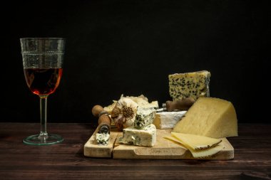 Manchego ile hayat kuzu peyniri ve Fransız mavi peyniri bıçaklı, sarımsaklı ve bir bardak İspanyol gül şarabıyla dolu.
