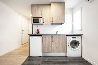 Mobilyalı stüdyo daire, mutfağı var. Gri madra ve meşe kaplı ahşap döşemeleri var.