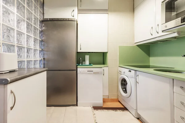 绿色石头台面 白色橱柜和家用电器柱 灰色地板 — 图库照片