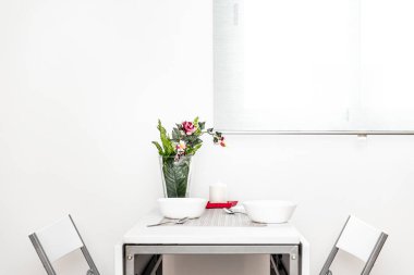 Küçük beyaz katlanır yemek masası, uygun sandalyeler, suni bitki vazosu seti.