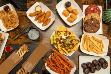 Patates kızartmalı fast food menüleri, tatlı patates cipsi, çikolata palmiyesi, nachos cho guacamole, soğan halkaları, kızarmış yucca ve hamurda kızarmış tavuk.